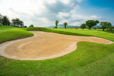 Scenic view of golf course against sky