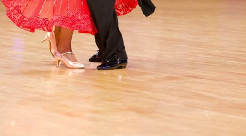 Low section of women standing on hardwood floor