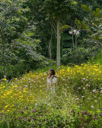 Woman standing by flowering tree