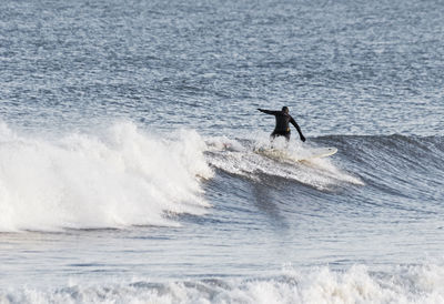 Man jumping in sea against sky