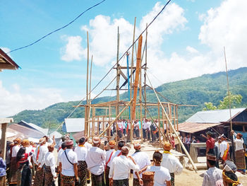 Group of people in front of built structure against sky