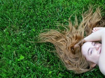 Woman lying on grassy field