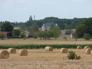 Hay bales on field against sky