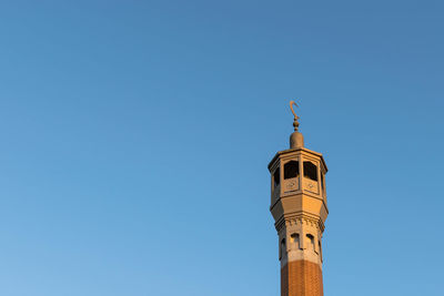 Low angle view of bell tower against clear blue sky