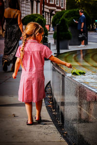 Rear view of woman walking on footpath