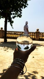Midsection of woman holding glass against clear sky