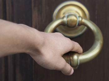 Cropped image of hand holding door knocker