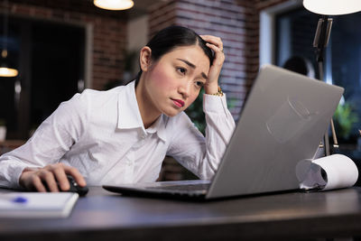 Young woman using laptop on table