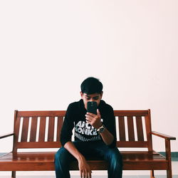 Rear view of young man sitting on bench