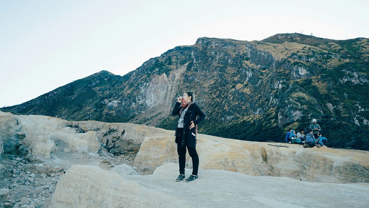 mountain, lifestyles, leisure activity, full length, casual clothing, young adult, mountain range, clear sky, standing, young men, rock - object, backpack, person, men, tourist, nature, day