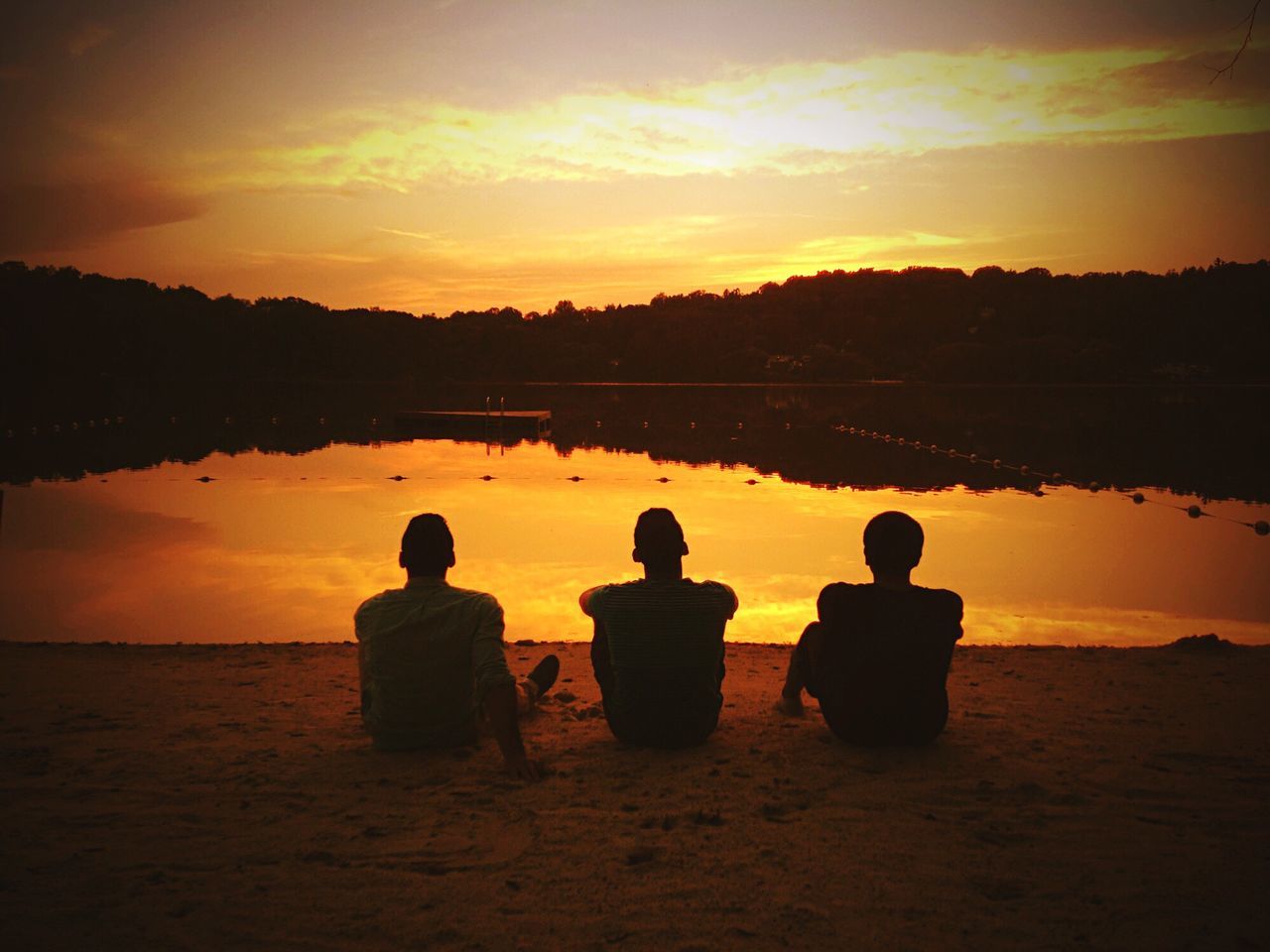 sunset, water, sitting, rear view, silhouette, men, lake, tranquility, tranquil scene, relaxation, orange color, reflection, romantic sky, togetherness, scenics, calm, solitude, sky, weekend activities, outdoors, beauty in nature, nature, person, vibrant color, in front of, summer, sea