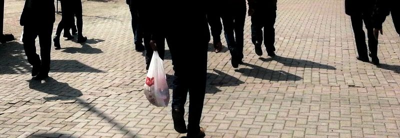 Low section of woman walking on footpath