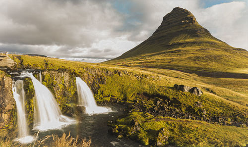 Scenic view of waterfall against sky