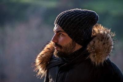 Portrait of young man looking away outdoors