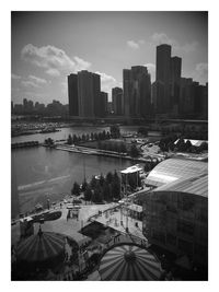 Aerial view of river amidst buildings in city against sky