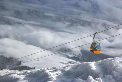 Overhead cable car over snowcapped mountains against sky