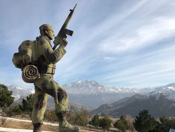 Low angle view of statue on mountain against sky