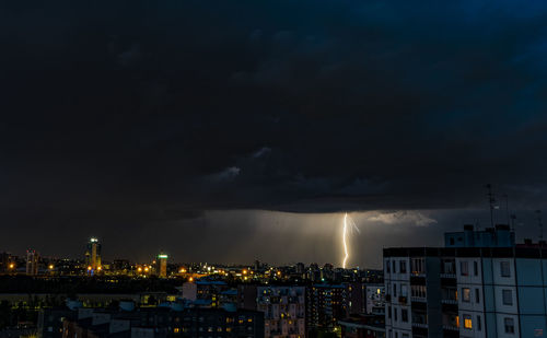 Illuminated buildings in city against sky at night