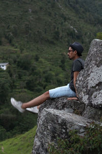Side view of young woman standing on rock