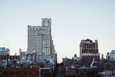 Buildings in city against clear sky