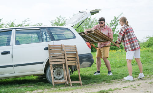 Rear view of man standing on car