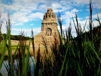 Built structure on landscape against cloudy sky