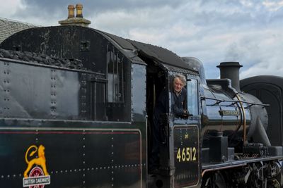 Portrait of man standing by train against sky