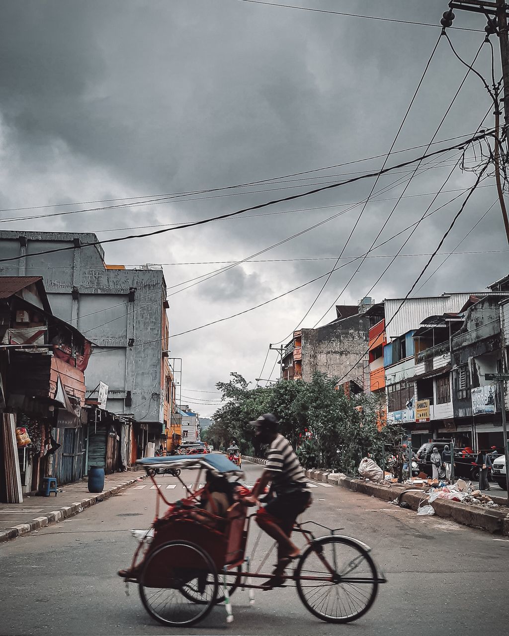 BICYCLE ON STREET BY BUILDINGS AGAINST SKY