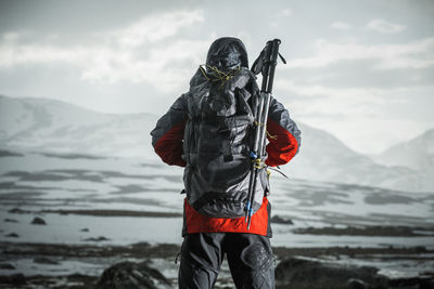 Rear view of woman standing on snow covered mountain