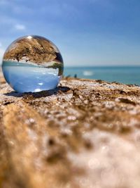 Close-up of beach against blue sky