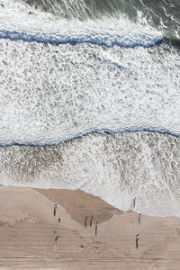 High angle view of people standing at beach by sea