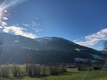 Scenic view of field and mountains against sky