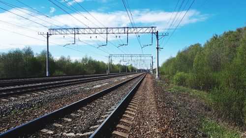 Railroad tracks by electricity pylon against sky