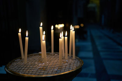 Close-up of illuminated candles on table at night