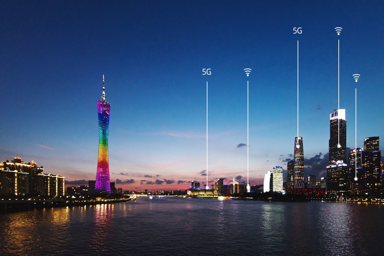 ILLUMINATED MODERN BUILDINGS AGAINST SKY AT NIGHT