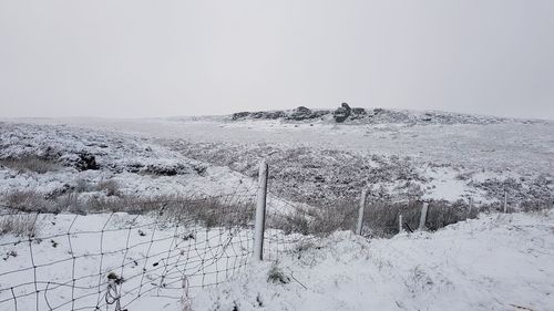 Scenic view of snow covered land against sky