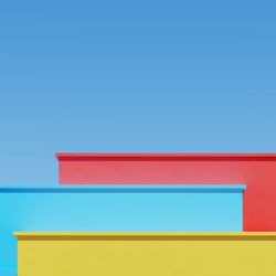 Low angle view of multi colored wall against blue sky