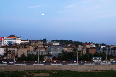 Buildings in city against blue sky