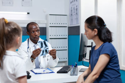 Doctor showing digital tablet to patient at clinic