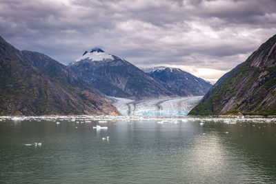 Scenic view of lake by mountains against sky