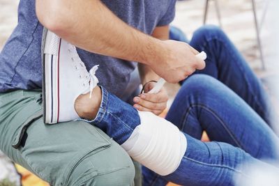 Low section of man tying shoelace