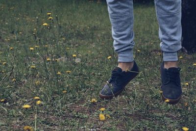 Low section of man levitating on grassy field