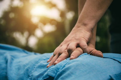 Close-up of man hand on bed