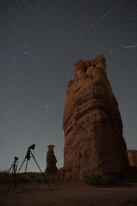 Low angle view of rock formation against star field