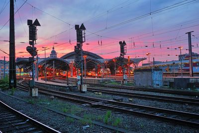 Train at railroad station against sky during sunset