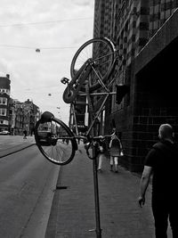 Rear view of man with bicycle standing in city