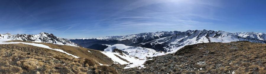 Scenic view of snowcapped mountains against blue sky