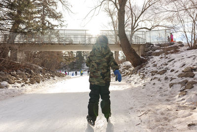 Young boy skating on ice on a sunny winter day