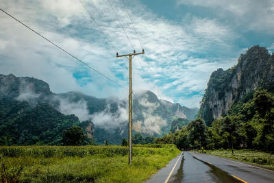 Road by mountains against sky