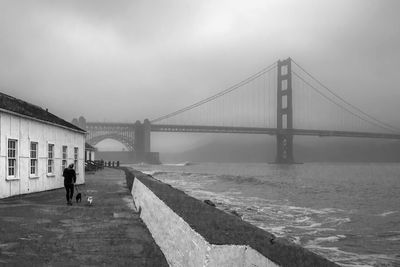 Man walking on bridge over river